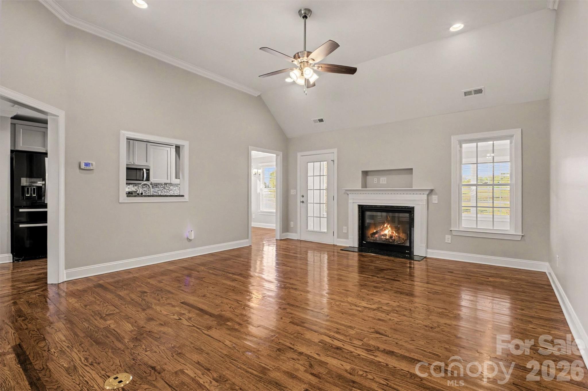 3604 Rilla Hamilton Road Monroe, NC 28110 - Photo 10 of 46 an empty room with wooden floor fireplace and windows