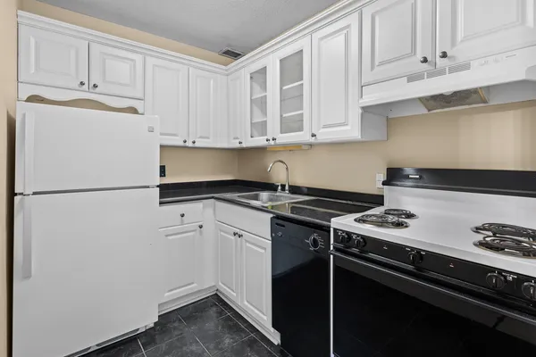 a kitchen with a stove and white cabinets