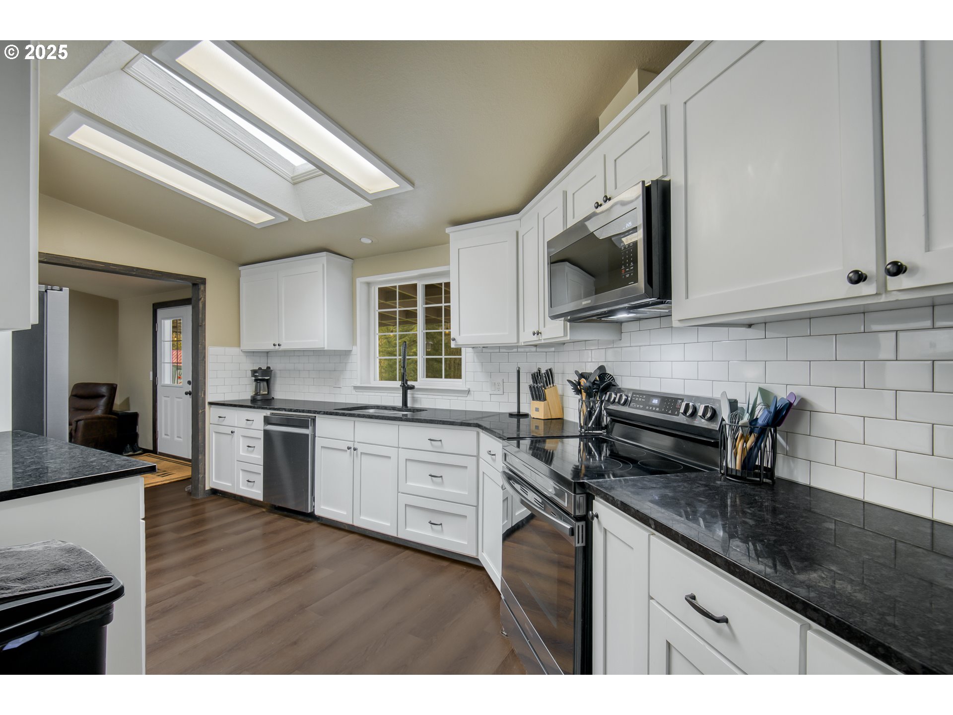 34241 Southeast Colorado Road Sandy, OR 97055 - Photo 7 of 37 a kitchen with granite countertop a sink a stove top oven and cabinetry