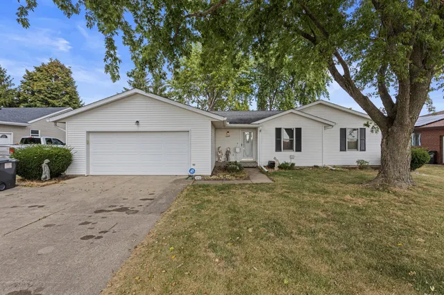 a view of a house with a yard and large trees