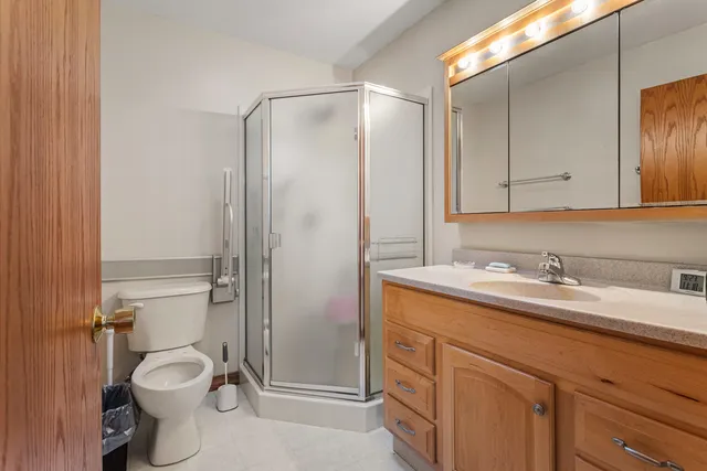 a bathroom with a granite countertop sink toilet and shower