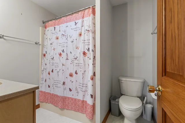 a bathroom with a toilet and a shower curtain