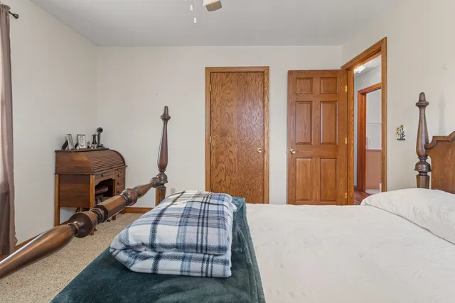 a bedroom with bed and wooden floor