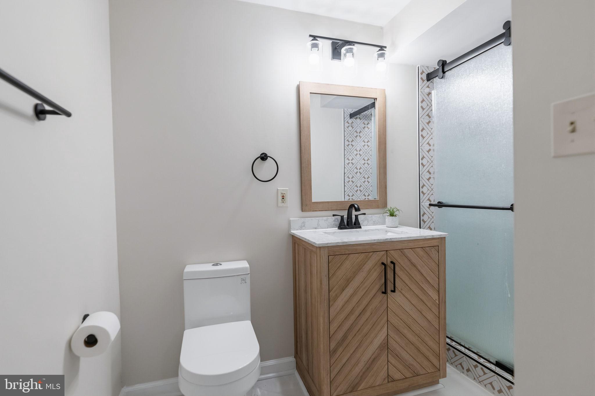 7603 Modisto Lane Springfield, VA 22153 - Photo 42 of 57 a bathroom with a toilet a sink and mirror