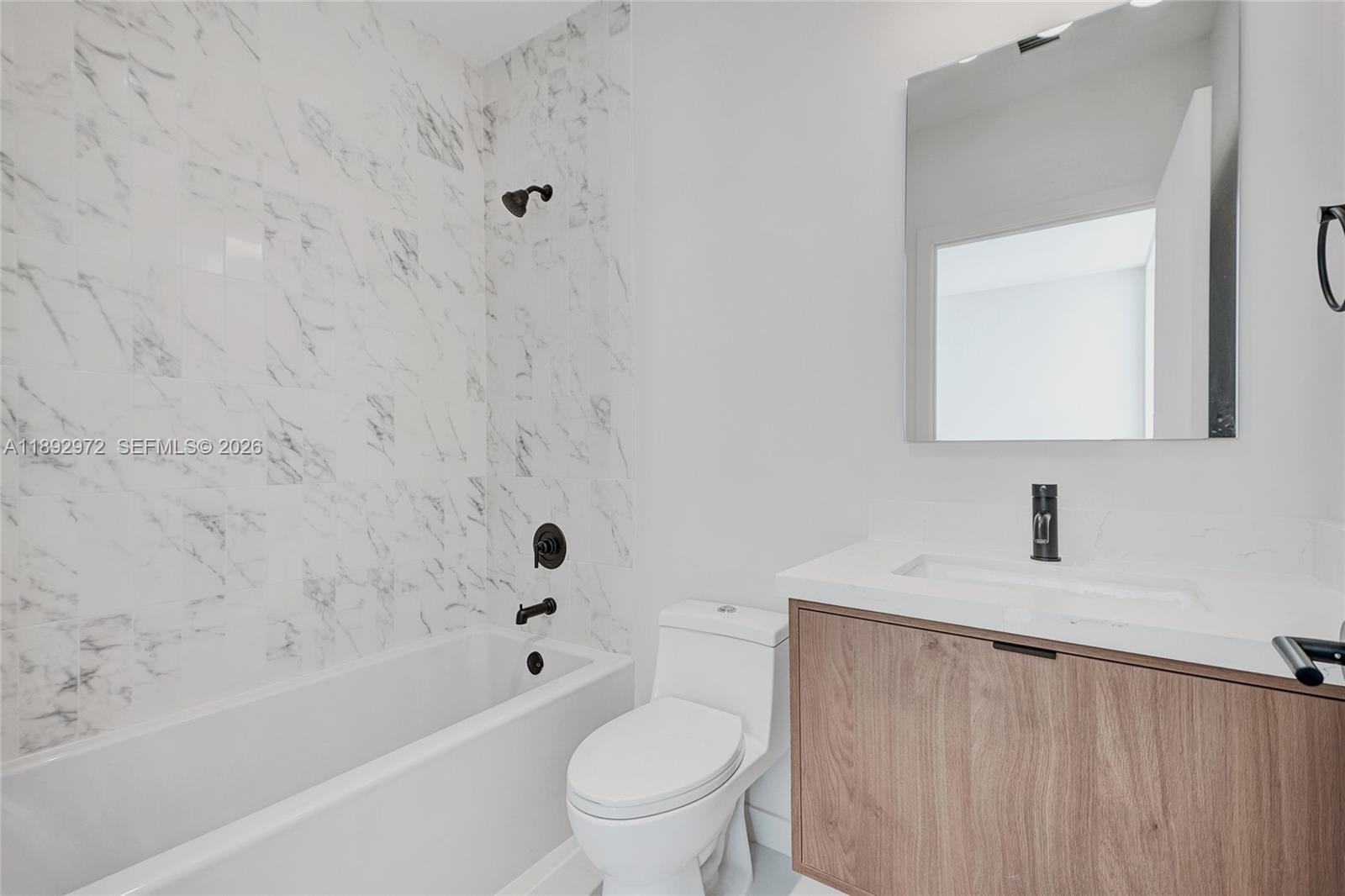 525 Northeast 61st Street Miami, FL 33137 - Photo 15 of 37 a bathroom with a bathtub sink vanity mirror and toilet