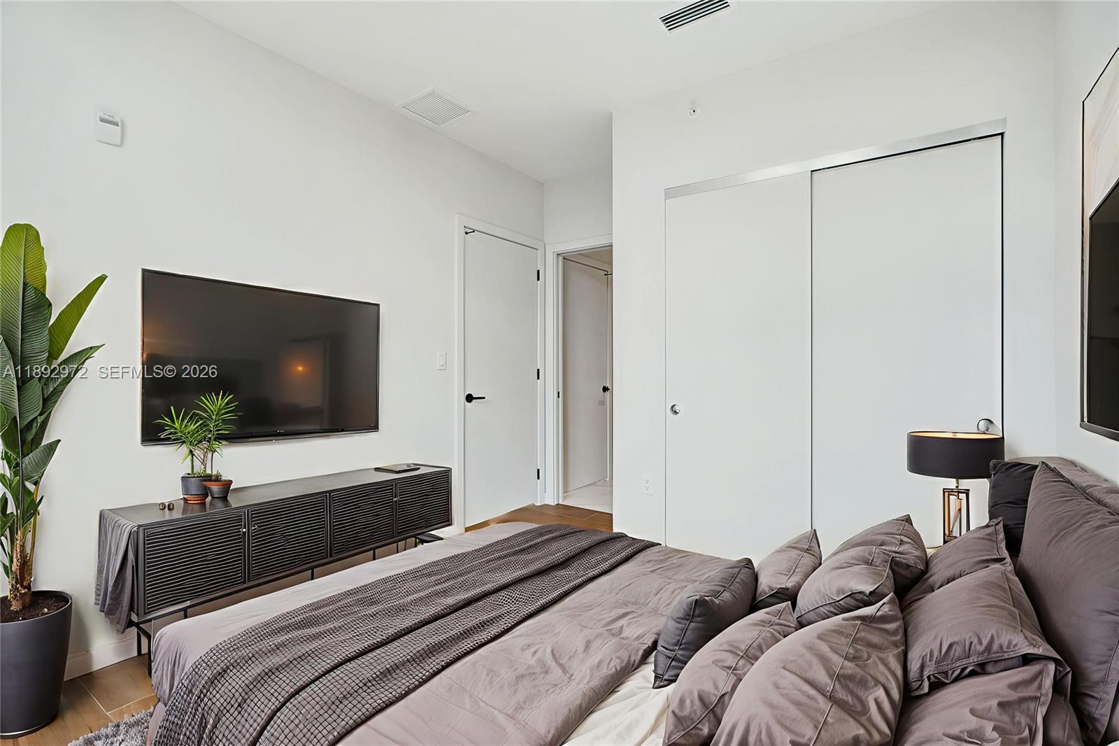 525 Northeast 61st Street Miami, FL 33137 - Photo 10 of 37 a bedroom with a bed and a flat screen tv