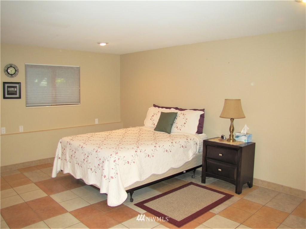 226 Guy Kelly Road Port Angeles, WA 98362 - Photo 12 of 40 a bed sitting in a bedroom next to a lamp