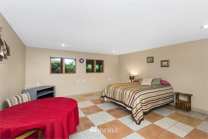 226 Guy Kelly Road Port Angeles, WA 98362 - Photo 17 of 40 a bedroom with a bed lamp and a large window
