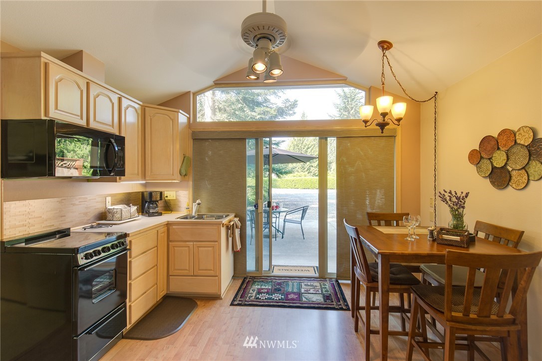 226 Guy Kelly Road Port Angeles, WA 98362 - Photo 25 of 40 a kitchen with a table chairs stove and cabinets