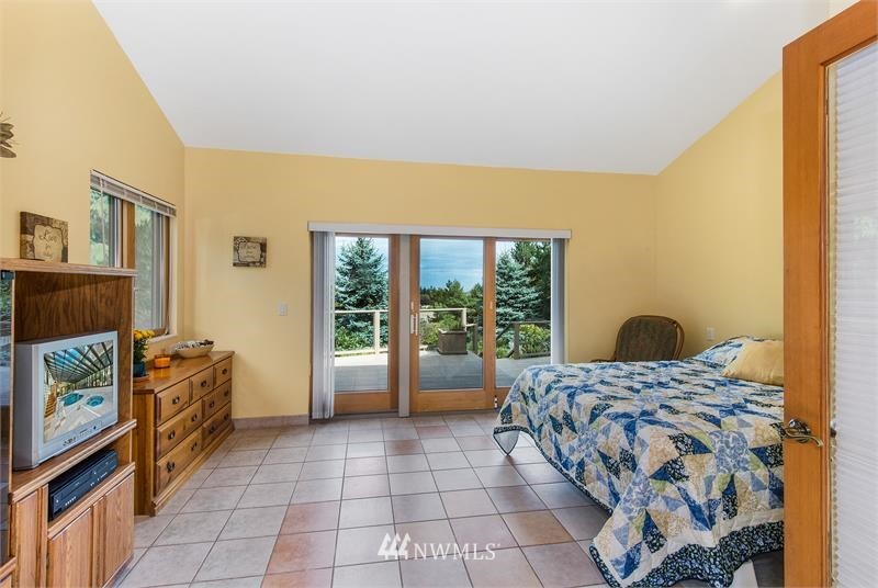 226 Guy Kelly Road Port Angeles, WA 98362 - Photo 27 of 40 a bedroom with a bed and a flat tv screen on the dresser
