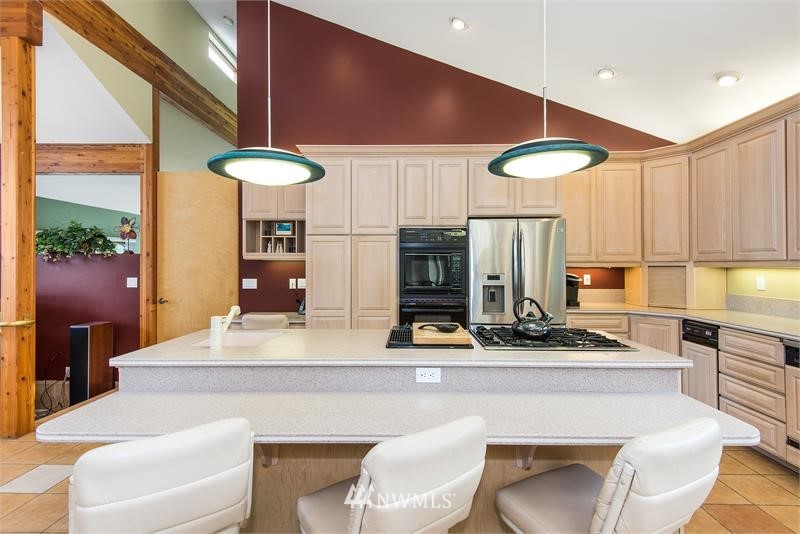 226 Guy Kelly Road Port Angeles, WA 98362 - Photo 6 of 40 a kitchen with stainless steel appliances kitchen island granite countertop a table chairs sink and cabinets