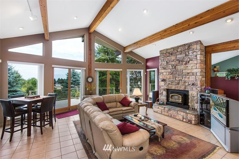 226 Guy Kelly Road Port Angeles, WA 98362 - Photo 8 of 40 a living room with furniture a fireplace and a floor to ceiling window