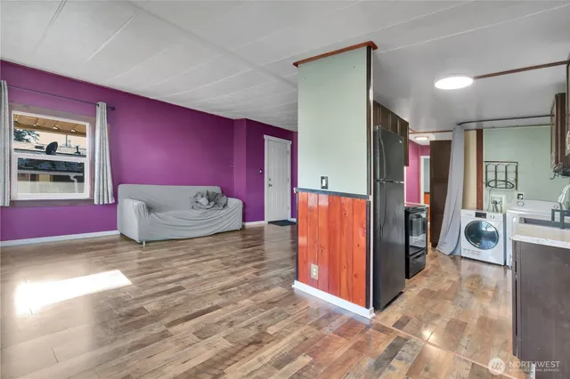 a view of a bedroom with a bed and wooden floor