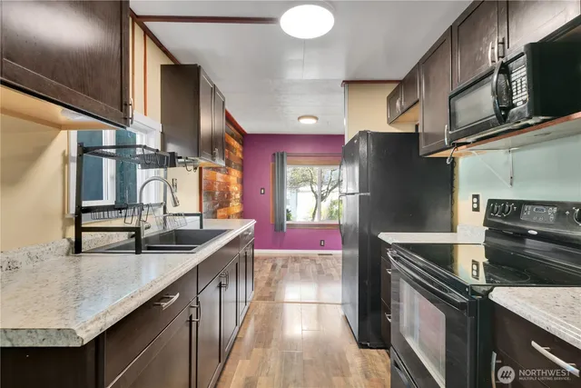 a kitchen with stainless steel appliances granite countertop a sink a stove and a refrigerator