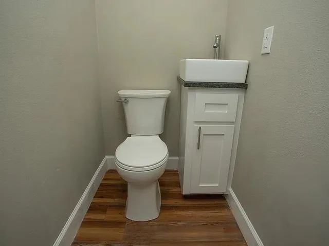 a white toilet sitting next to a bathroom sink