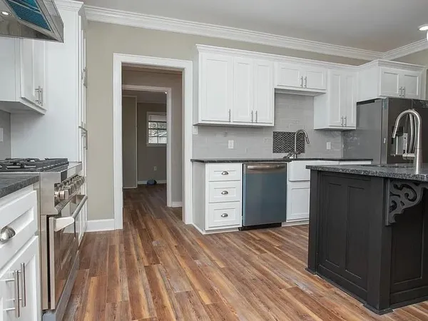 a kitchen with stainless steel appliances granite countertop a stove a sink and a refrigerator
