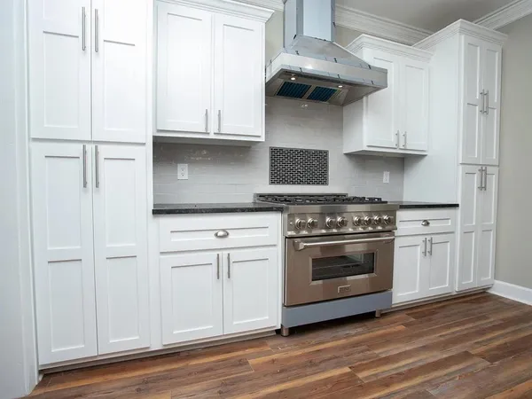 a kitchen with stainless steel appliances white cabinets and a stove