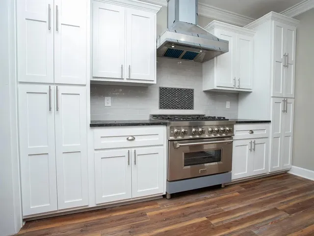 a kitchen with stainless steel appliances white cabinets and a stove