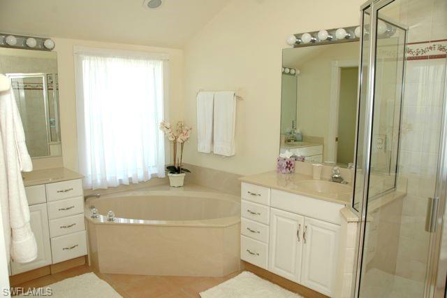 590 East Lake Drive Naples, FL 34102 - Photo 11 of 11 Bathroom featuring vanity, shower with separate bathtub, and vaulted ceiling