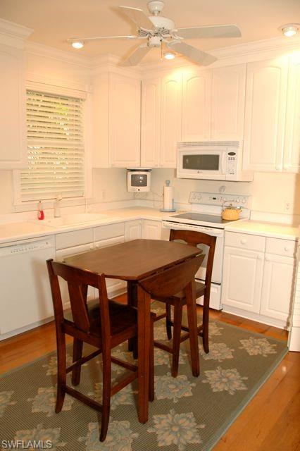 590 East Lake Drive Naples, FL 34102 - Photo 6 of 11 Kitchen featuring sink, white cabinets, dark hardwood / wood-style flooring, ceiling fan, and white appliances