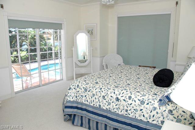 590 East Lake Drive Naples, FL 34102 - Photo 7 of 11 Carpeted bedroom featuring crown molding and access to outside