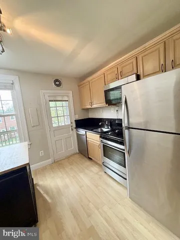 a kitchen with a refrigerator and a stove top oven