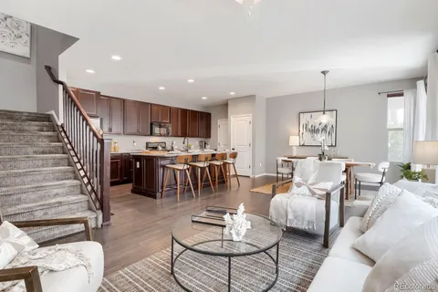 a living room with furniture kitchen view and a chandelier