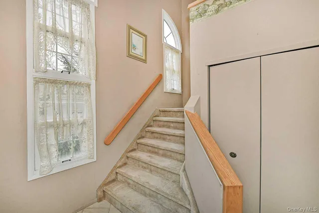 a view of staircase with white walls and wooden floor