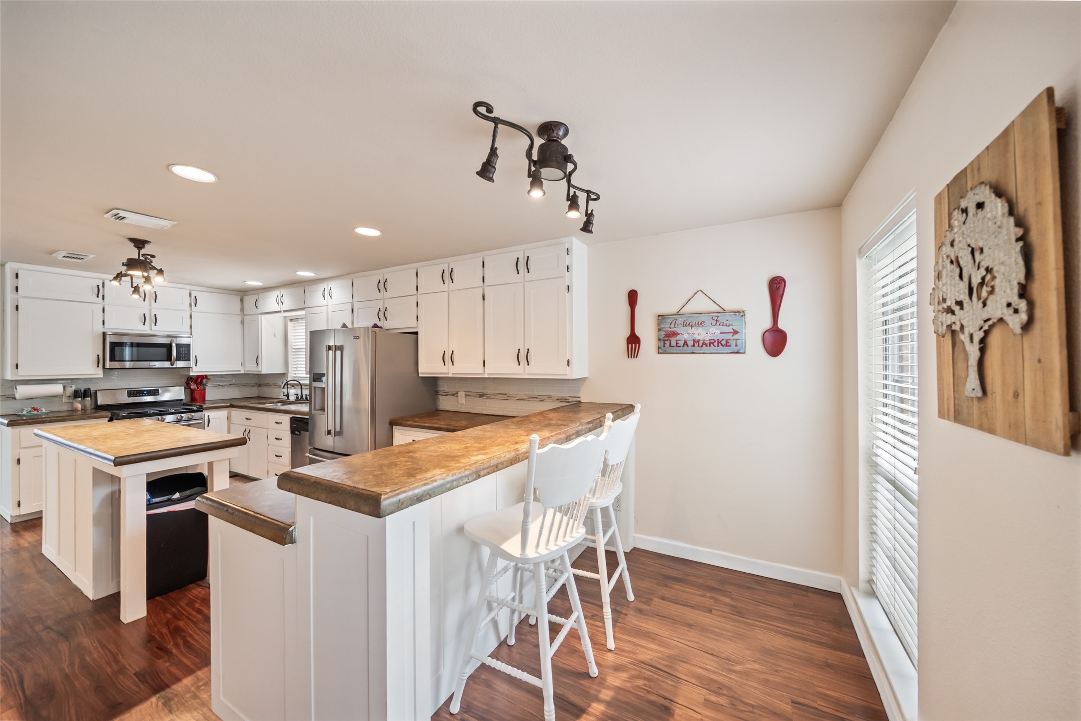 600 Hampton Hall Lane Conroe, TX 77302 - Photo 12 of 32 a kitchen with a stove a refrigerator and a dining table