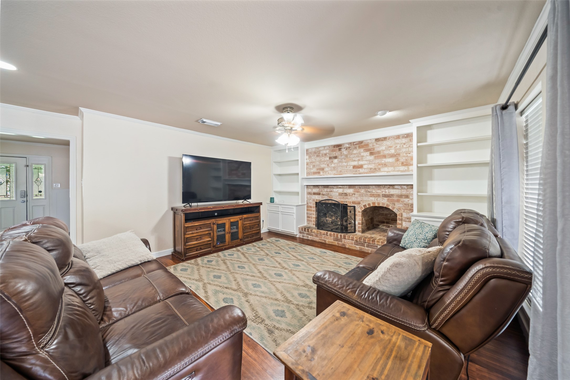 600 Hampton Hall Lane Conroe, TX 77302 - Photo 15 of 32 a living room with furniture a flat screen tv and a fireplace