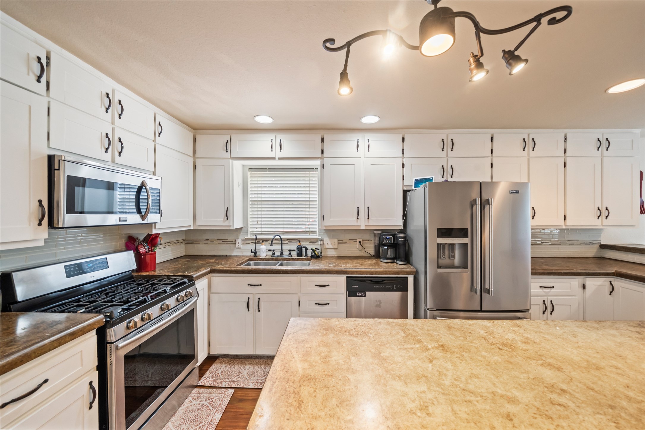 600 Hampton Hall Lane Conroe, TX 77302 - Photo 9 of 32 a kitchen with stainless steel appliances a refrigerator stove and sink