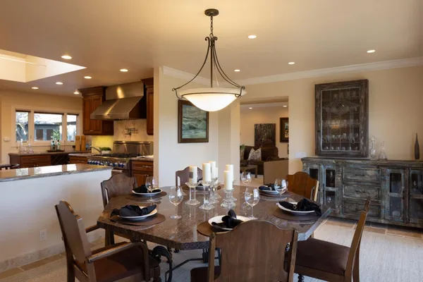 a view of a dining room and livingroom with furniture wooden floor a chandelier