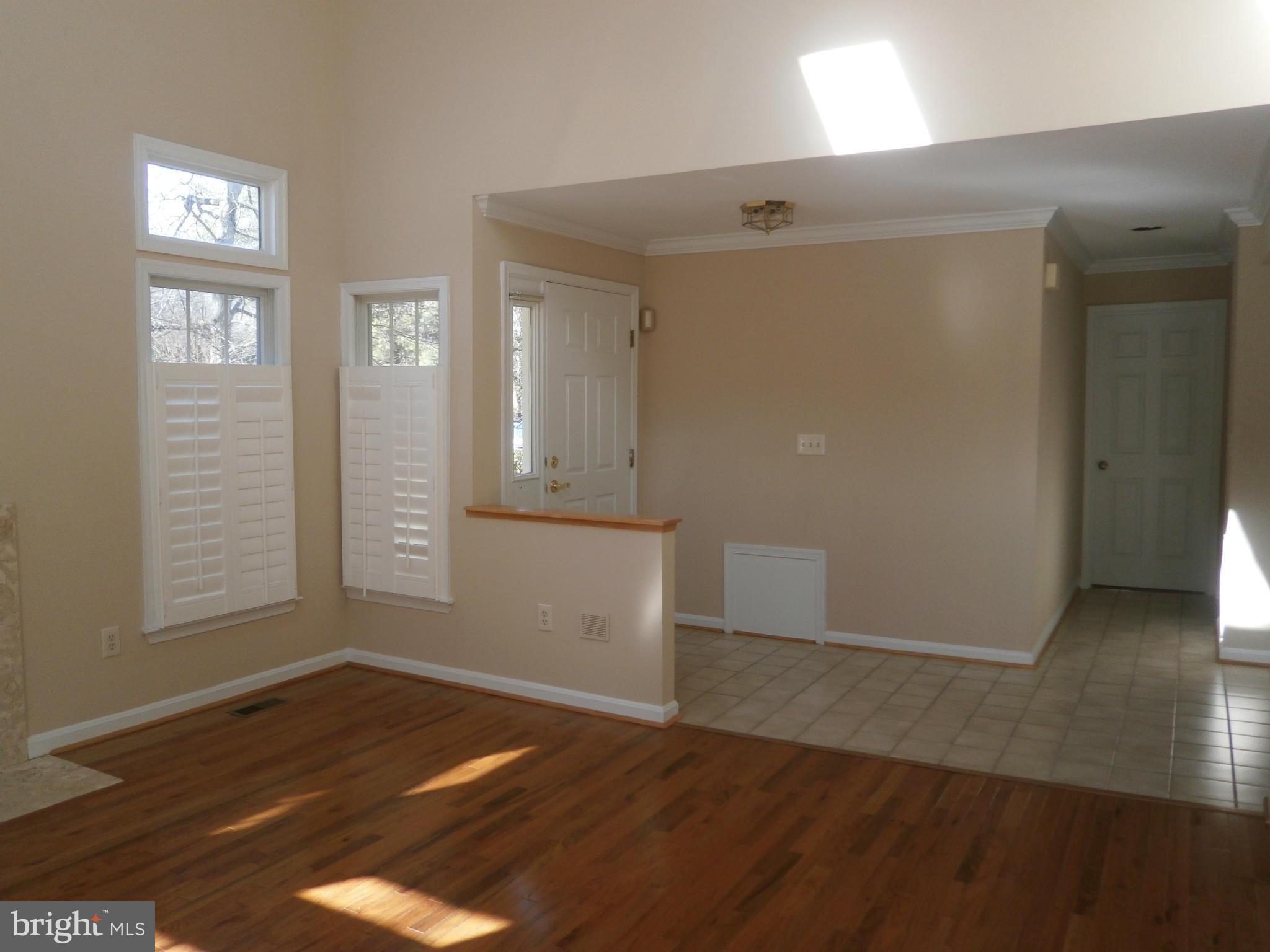 100 Spring Pl Way Annapolis, MD 21401 - Photo 3 of 15 an empty room with wooden floor and windows