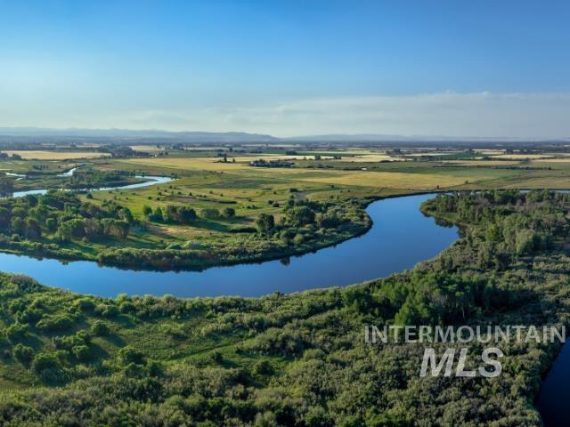 6891 West 2000 South Rexburg, ID 83440 - Photo 4 of 50 Aerial view of a nearby body of water and a heavily wooded area