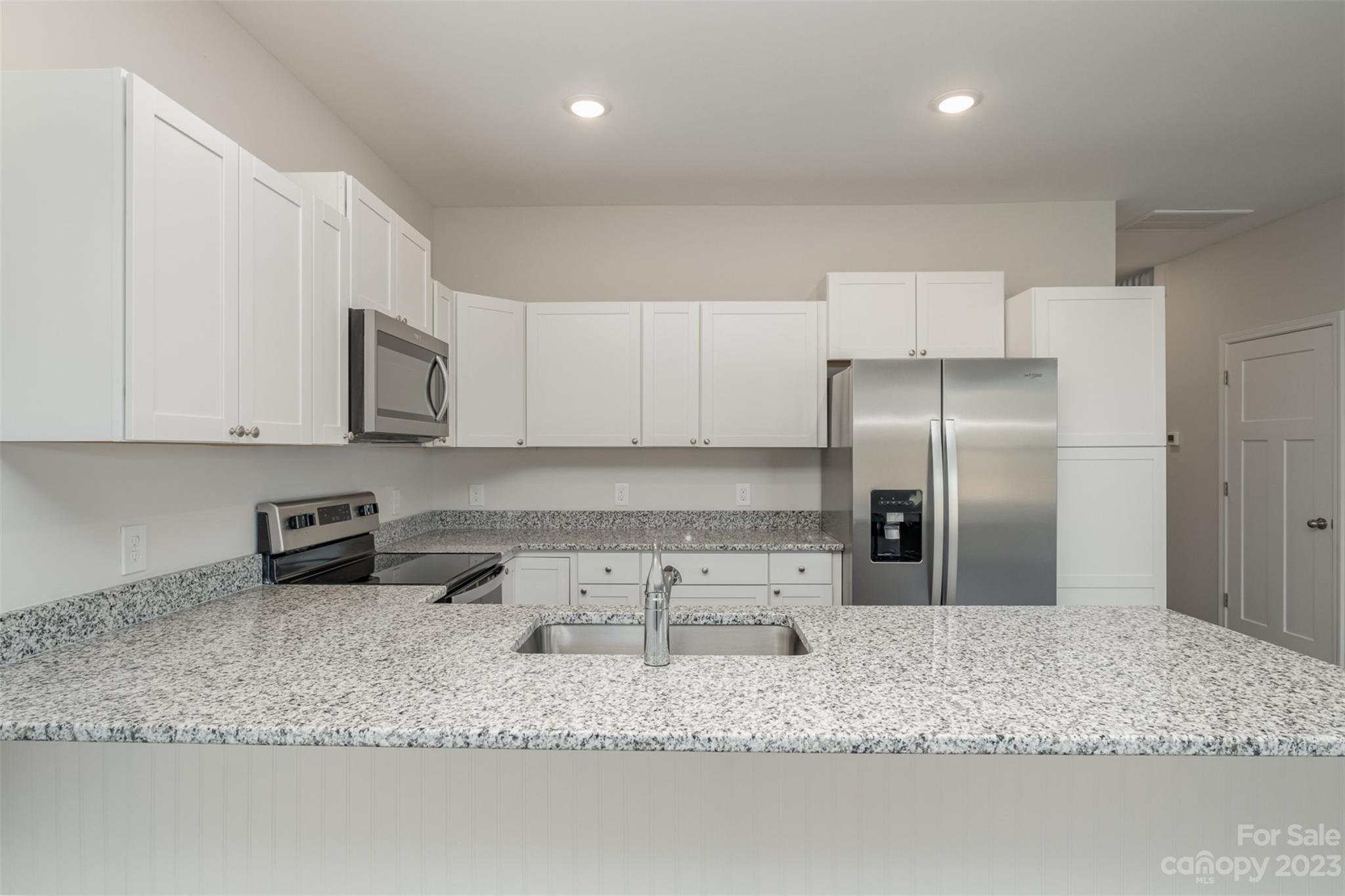 2870-2874 Fay Jones Road Denver, NC 28037 - Photo 6 of 23 a kitchen with stainless steel appliances granite countertop a sink a stove a microwave a sink and a counter top space