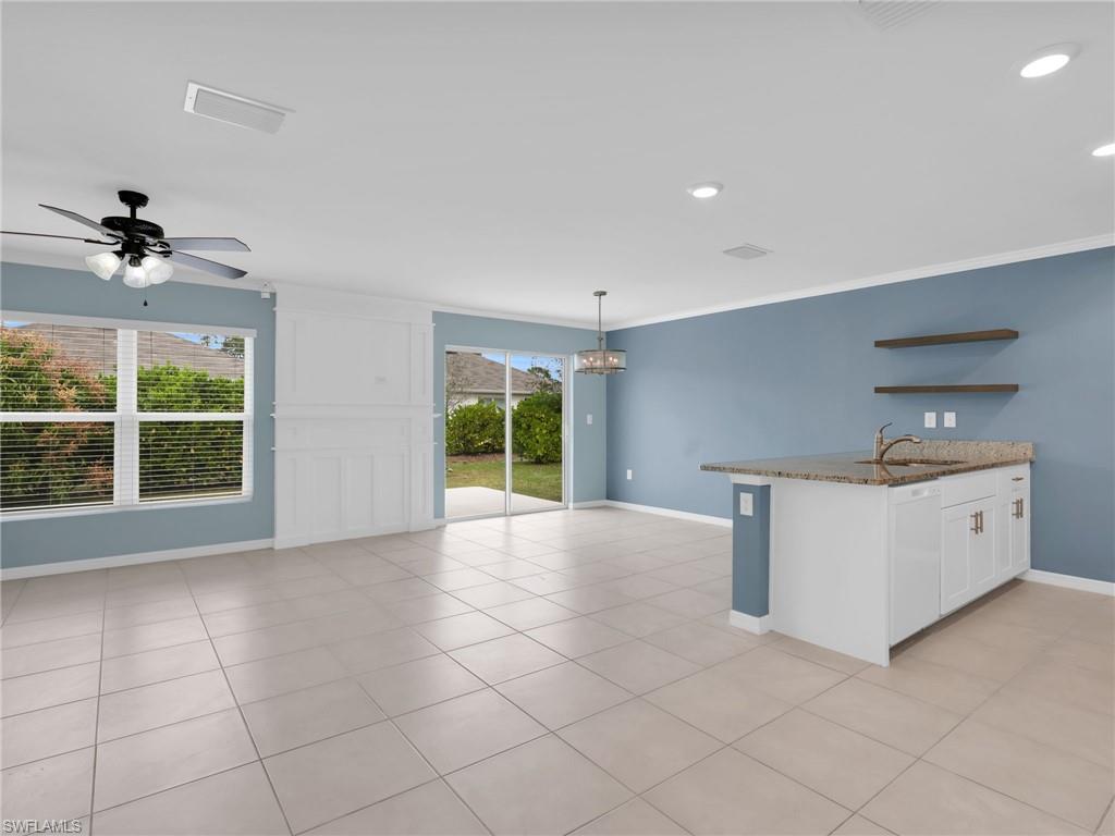 731 Hadley Place West Naples, FL 34104 - Photo 13 of 30 Great Room and Dining Area With Ceiling Fan, Chandelier, Tile Flooring, Faux Wood Blinds, Custom Woodwork Wall Feature, and Kitchen Island With Granite Countertop