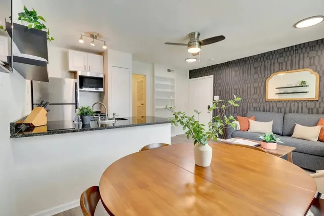 a dining room with furniture and a potted plant