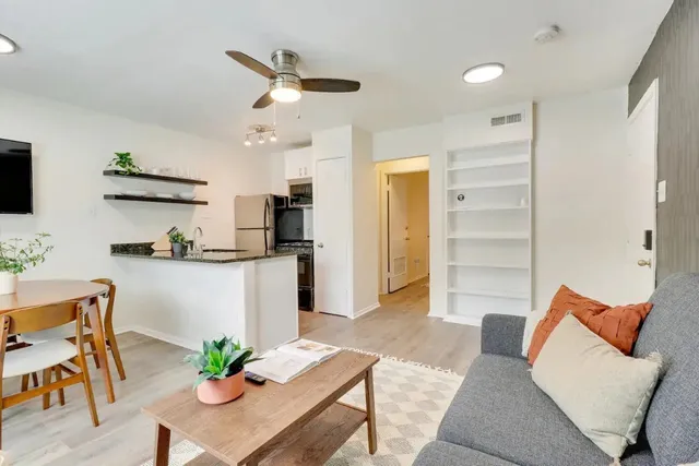 a living room with furniture and kitchen view