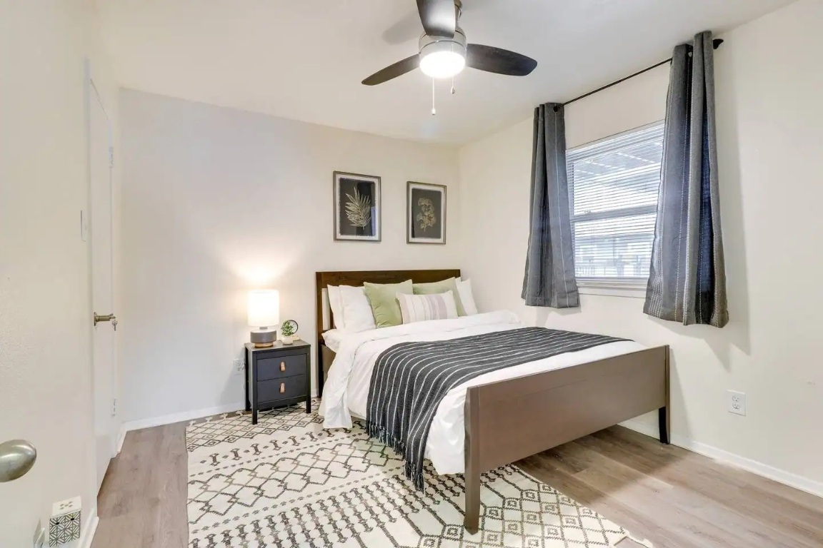 2401 Manor Road, Unit 129 Austin, TX 78722 - Photo 10 of 21 a bedroom with a large bed and a chandelier