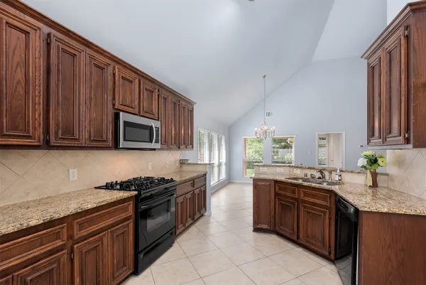 a kitchen with a stove a sink a counter space and a window