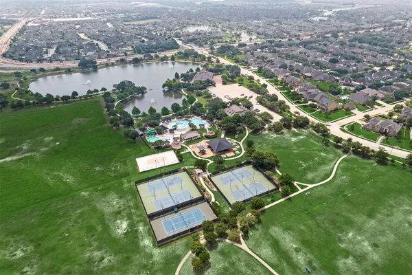 an aerial view of residential houses with outdoor space and trees