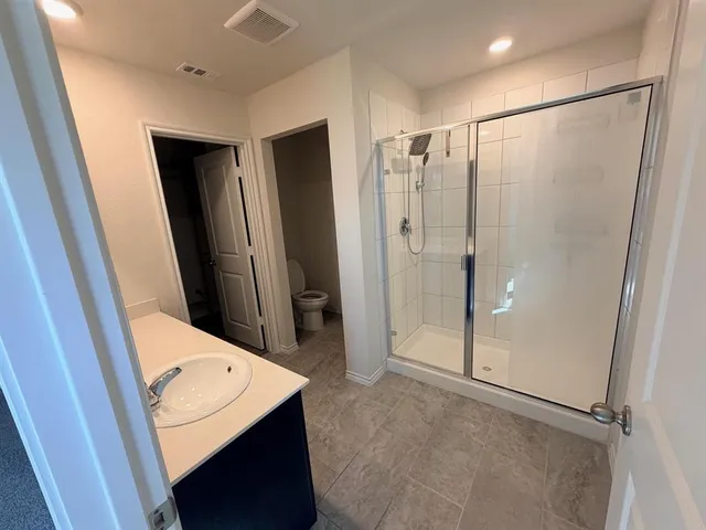 a bathroom with a shower sink and mirror