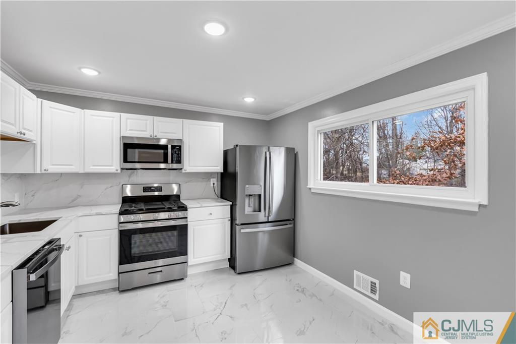 9 Nancy Circle Edison, NJ 08817 - Photo 20 of 38 a kitchen with stainless steel appliances granite countertop a refrigerator stove and microwave
