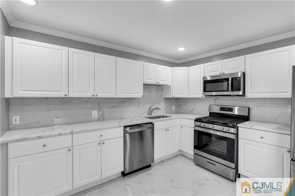 9 Nancy Circle Edison, NJ 08817 - Photo 21 of 38 a kitchen with white cabinets stainless steel appliances and sink