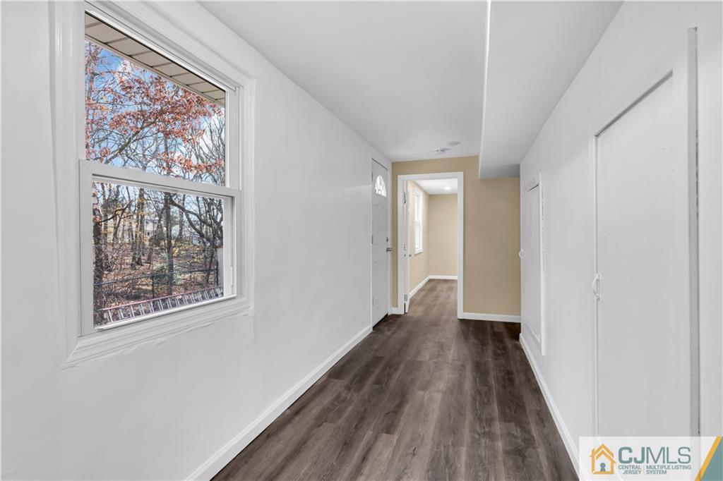 9 Nancy Circle Edison, NJ 08817 - Photo 35 of 38 a view of a hallway with wooden floor and a painting on the wall