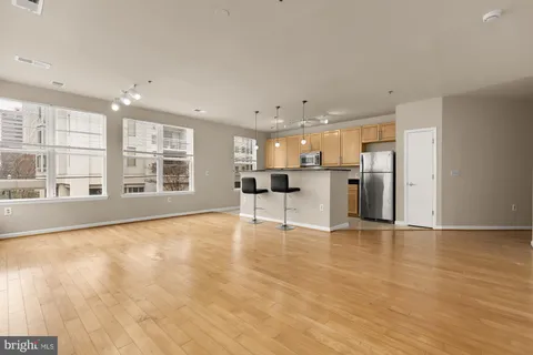 a view of an empty room with kitchen appliances and furniture