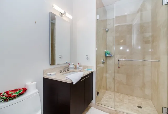 a bathroom with a sink vanity granite shower and a mirror