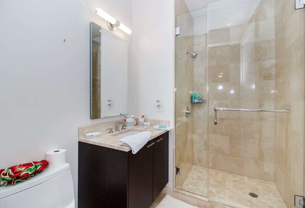 1 Franklin Street, Unit 5205 Boston, MA 02110 - Photo 16 of 40 a bathroom with a sink vanity granite shower and a mirror