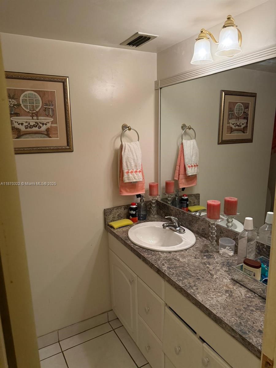 1710 Northeast 191st Street, Unit 3173 Miami, FL 33179 - Photo 14 of 18 a bathroom with a granite countertop sink and a mirror