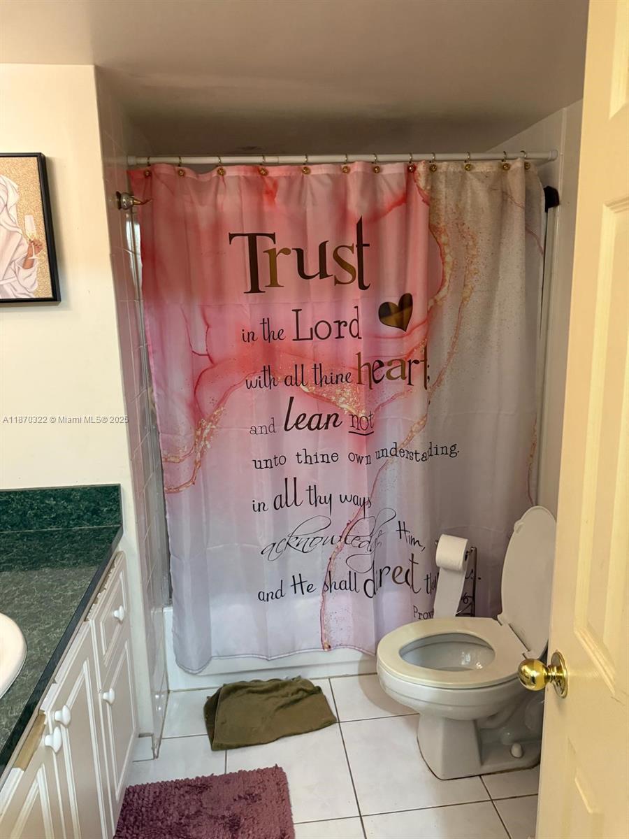 1710 Northeast 191st Street, Unit 3173 Miami, FL 33179 - Photo 15 of 18 a bathroom with a toilet and a shower curtain
